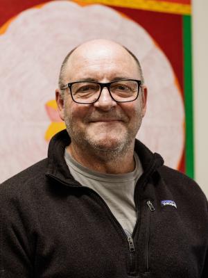 Simon Haberle standing in front of an artwork indoors